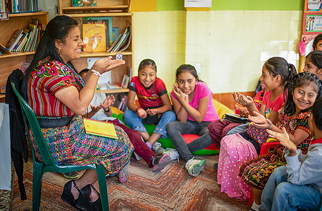 Child Aid literacy trainer Heidi Coyote Mactzul reads to a group of kids.