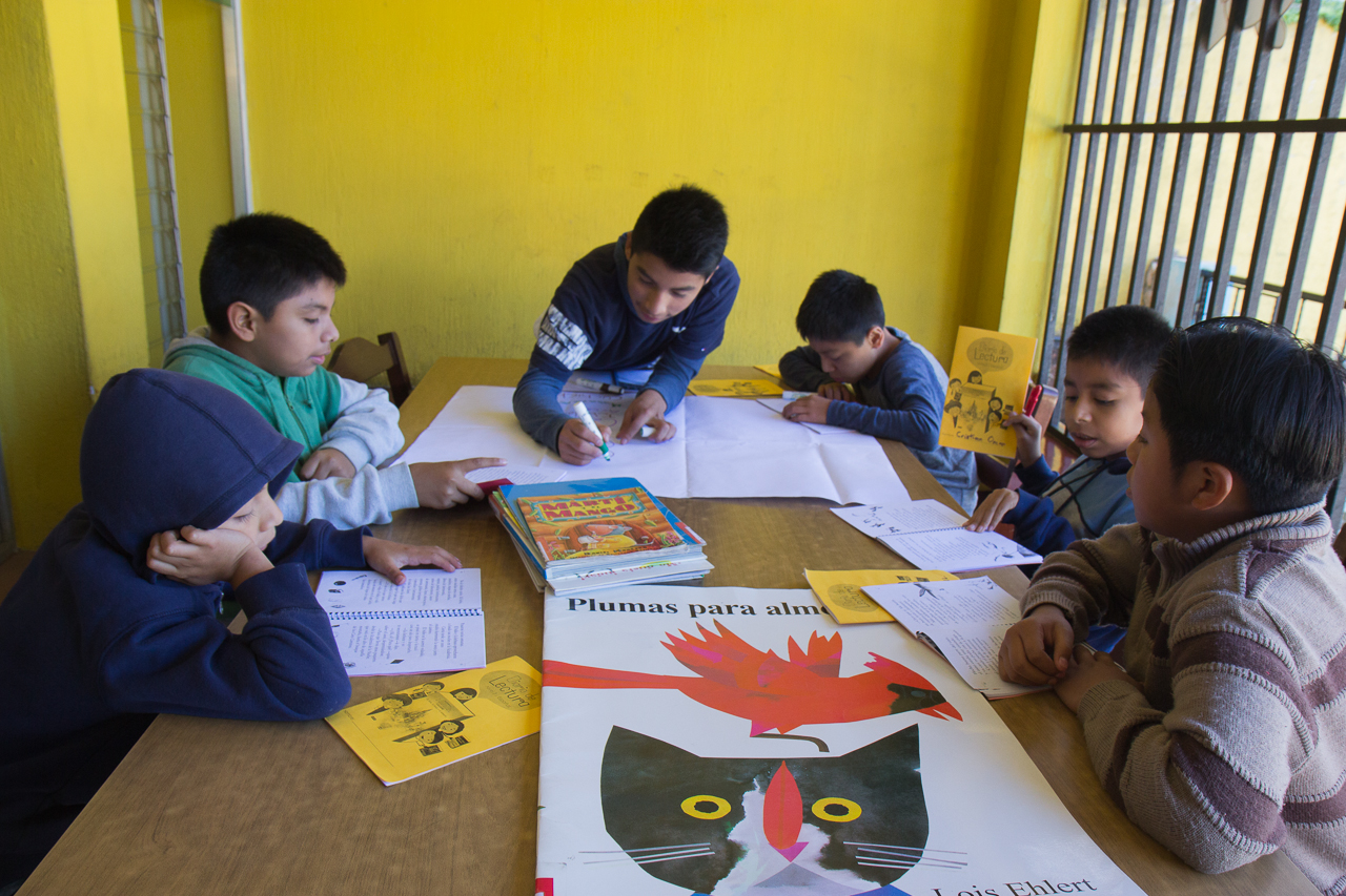 Members of the book club work on identifying unfamiliar words from their book "La Sopresa de la Noche."