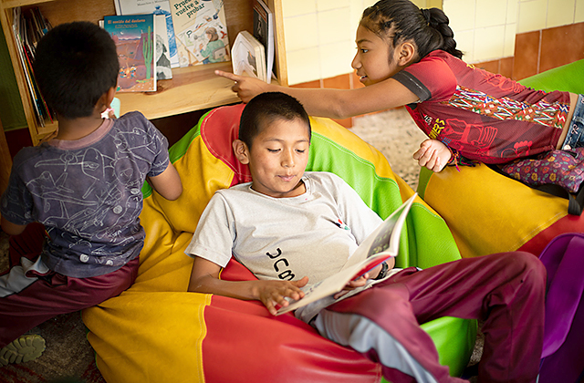 Child Aid literacy trainer Heidi Coyote Mactzul reads to a group of kids.